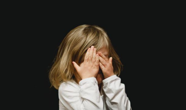 Niña tapándose los ojos